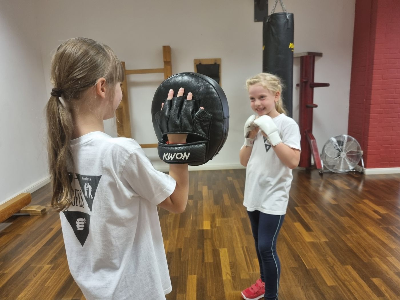 Zwei Mädchen trainieren mit Schlagpolster.
